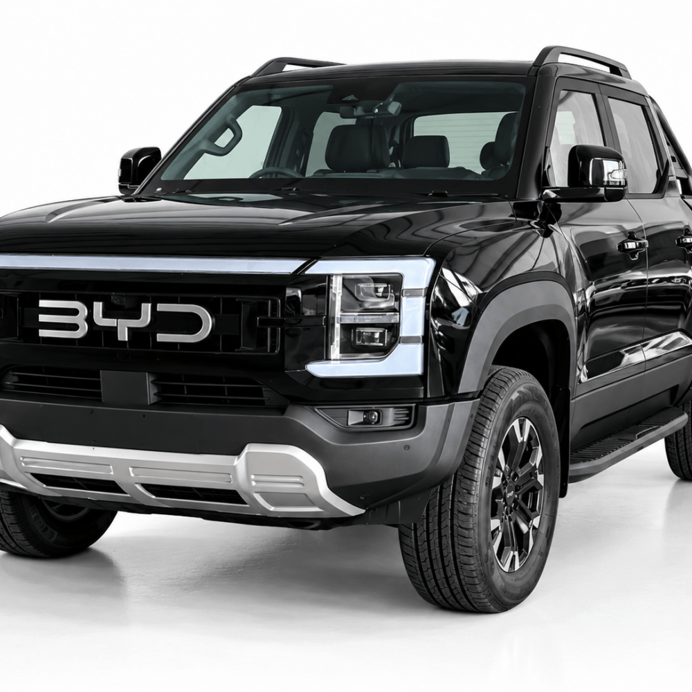 Front three-quarter view of a glossy black BYD pickup truck with a bold chrome grille and large off-road tires.